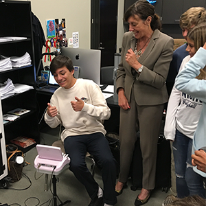 rosalie kramm poses with student giving a thumbs up over steno machine. Veritext Inspires Future Reporters