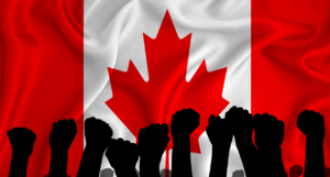 Silhouette of raised arms and clenched fists on the background of the flag of canada. The concept of power, power, conflict. With place for your text.